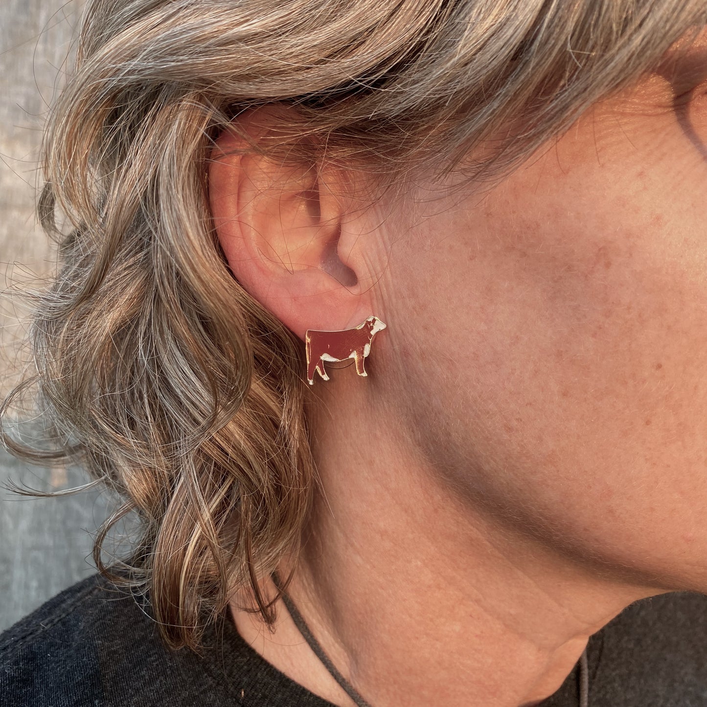 Red Hereford enamel hypo-allergenic post earrings displayed on an ear.