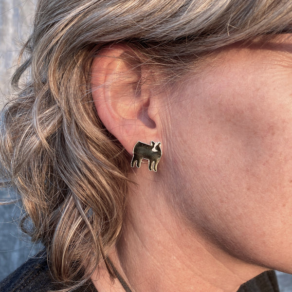 Black Baldy enamel hypo-allergenic post earrings on an ear.