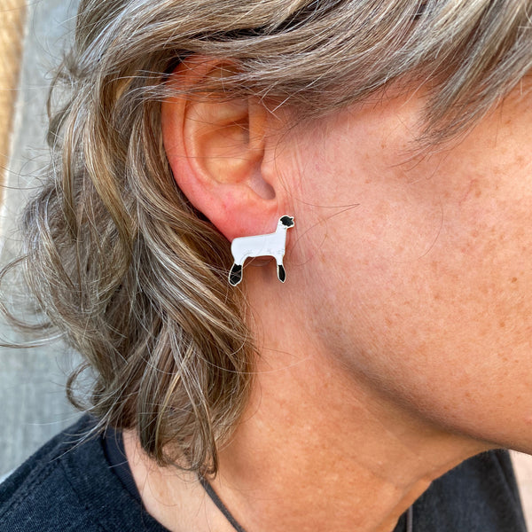 Black and white lamb enamel hypo-allergenic post earrings displayed on an ear.